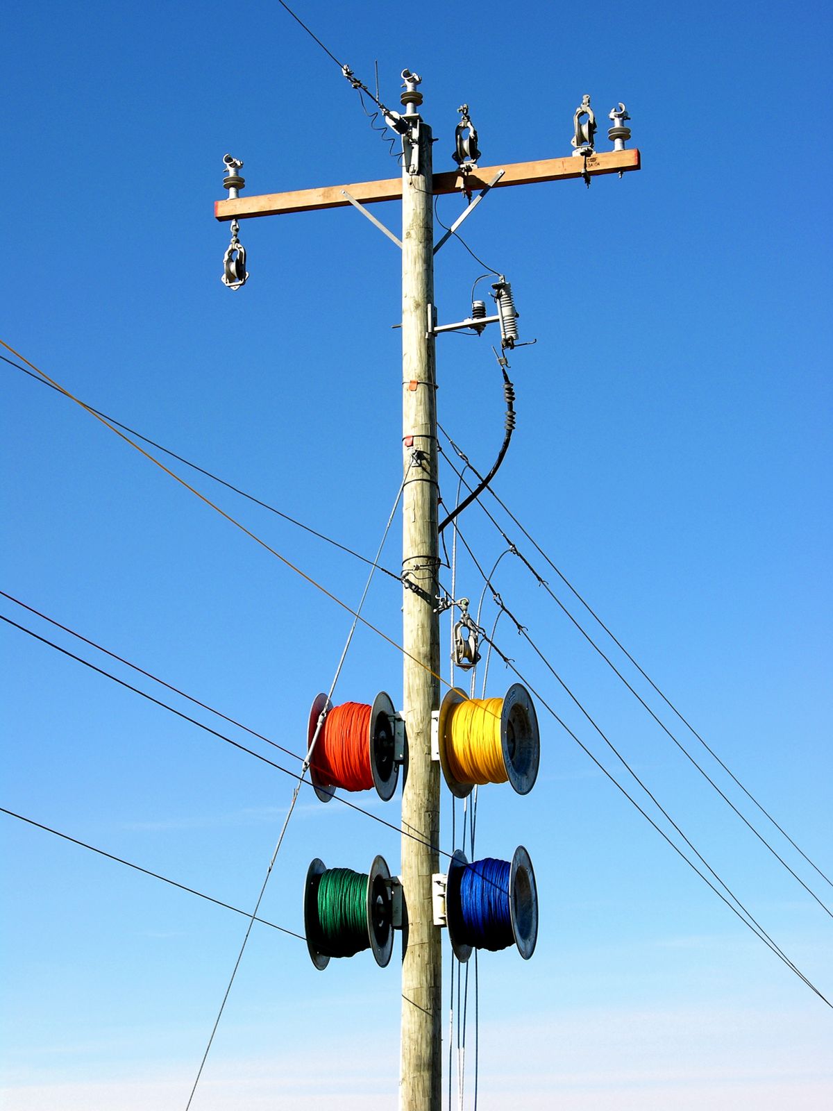 Colorful electrical cable spools on a utility pole