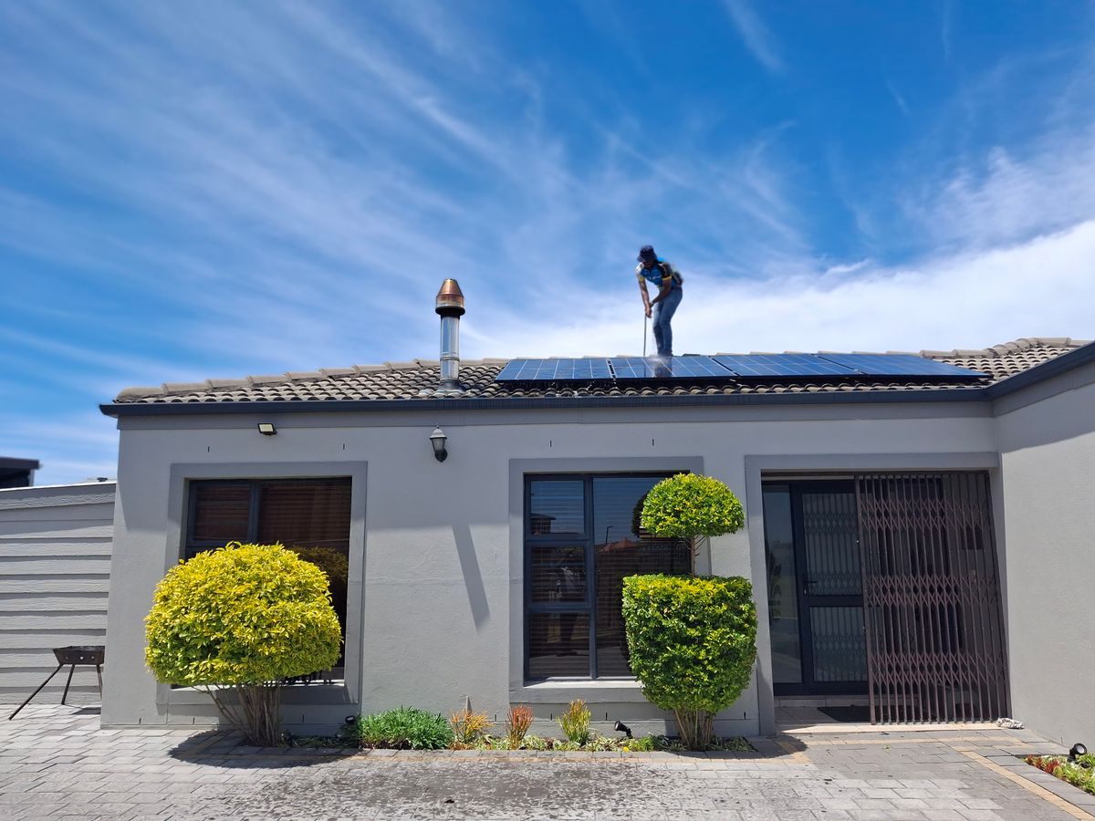 Worker installing solar panels on a residential roof