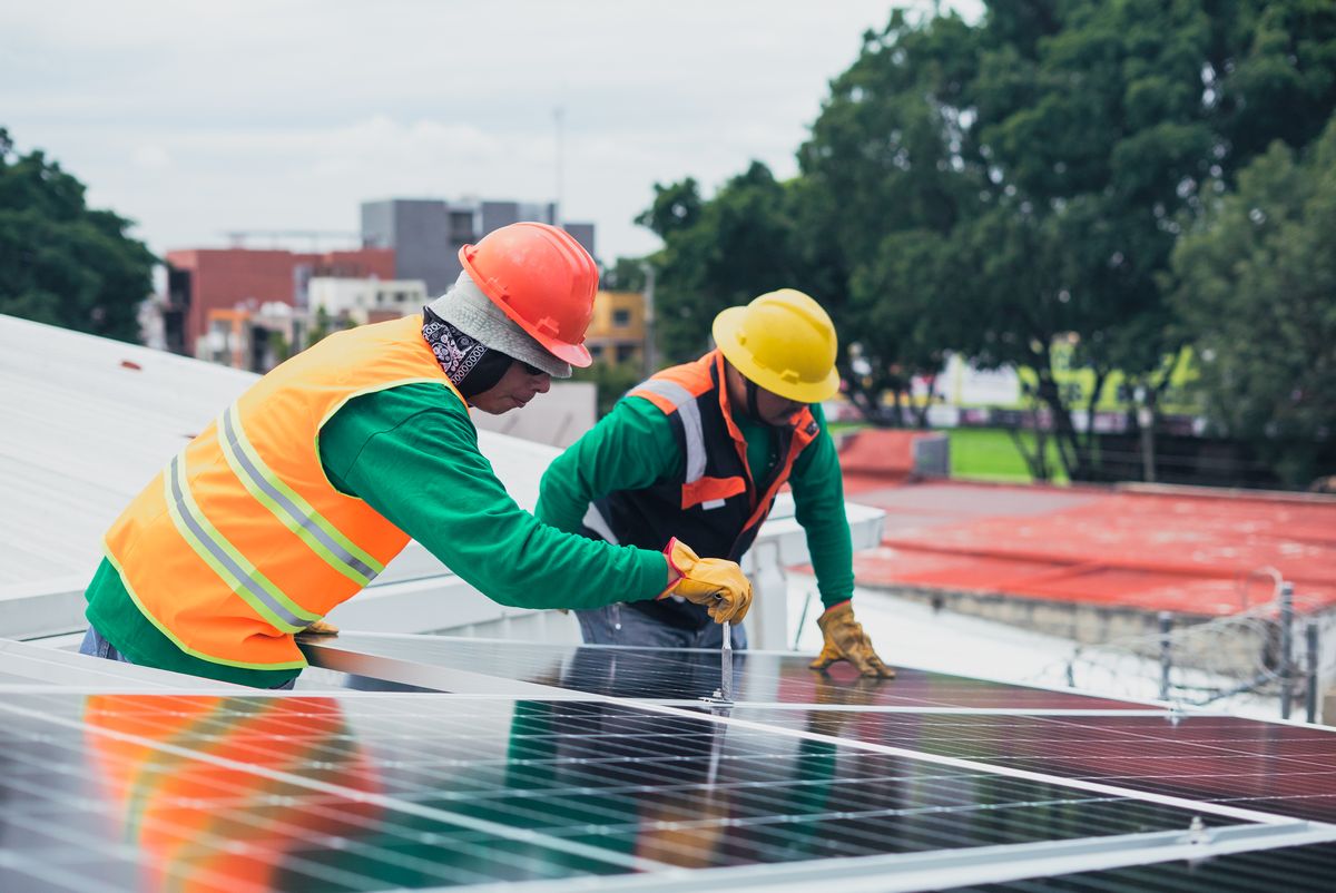 Technicians installing solar panels on a rooftop